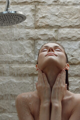 woman relaxing under shower with warm water pouring down, enjoying cleansing and refreshing moment...