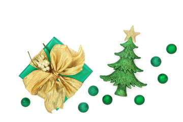 Green gift box, gold bow, mistletoe, Christmas tree, sphere bauble decorations on white background. Festive traditional holiday symbols with romantic theme.

