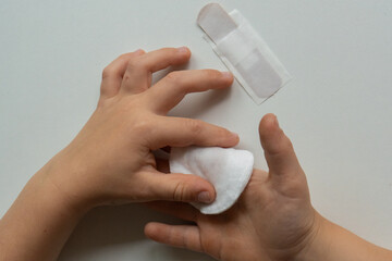Child applying bandage - first aid for minor injury concept