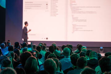 Person presenting digital content to engaged audience during professional technology event...