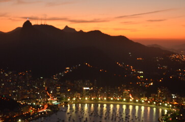 Sunset at night on Rio de Janeiro with city lights and the sea and the mountains