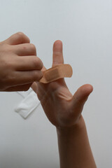 Child applying bandage - first aid for minor injury concept