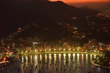 Sunset at night on Rio de Janeiro with city lights and the sea and the mountains