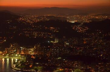 Sunset at night on Rio de Janeiro with city lights and the sea and the mountains