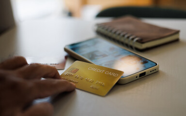 close up shot, man hand touching credit card on mobile phone, using mobile phone shopping online...