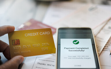 man hand holding credit card and using smart phone to paying expenses from using credit card via mobile app, online shopping concept and paying