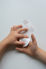 Child applying bandage - first aid for minor injury concept