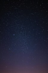 Fototapeta premium Dark blue night sky illuminated with countless stars, capturing the vastness of the cosmos in a tranquil outdoor environment