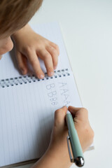 Child practicing handwriting in notebook - close-up educational series