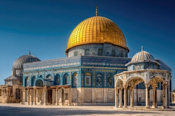 Obraz premium A majestic golden-domed shrine, adorned with intricate blue and white tilework, stands against a vibrant blue sky. Surrounding structures feature similar architectural details and open colonnades