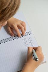 Child practicing handwriting in notebook - close-up educational series