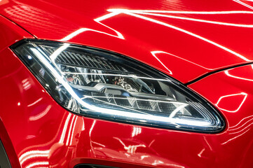 BI-LED headlights of a modern and expensive green car, hood and radiator grille. Front BI-LED...