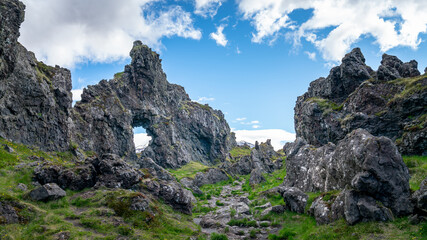 Volcanic lava formations on Djupalonssandur beach, set against the rugged coastline of Snaefellsnes peninsula in Iceland's Snaefellsjokull National Park.