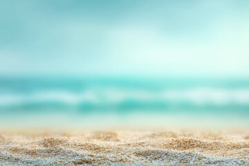 Soft-focus beach scene; pale sand in foreground sharply focused, out-of-focus turquoise ocean and hazy sky in background