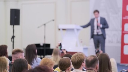 Business conference with speaker presenting to engaged audience. Professional atmosphere promoting teamwork and learning.