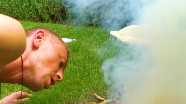 Burn leaves make bonfire man blows in fire in Belarus.