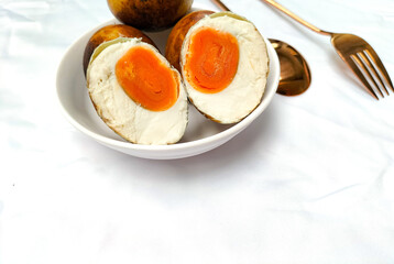 Selective focus. Grilled salted eggs from Brebes in a white bowl. Isolated white background. Duck...