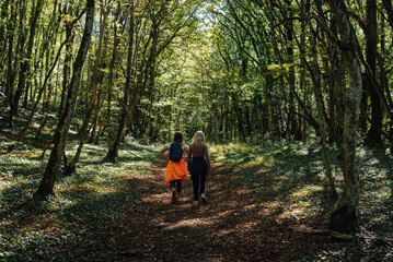 Obraz premium Deux femmes marchant dans la forêt. Balade dans les bois. Mère et fille se promenant. Couple lesbien. Homosexuel dans la nature. Randonnée extérieure