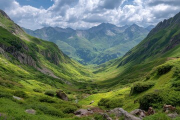 Naklejka premium Expansive alpine valley under a dramatic cloudy sky with lush green slopes and jagged peaks