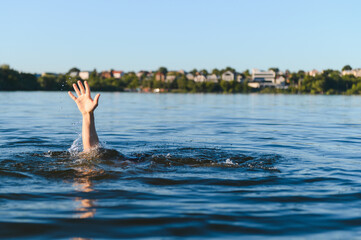 Man drowning in water, reaching for help near city