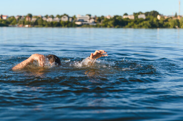 Man drowning in a lake is gasping for air near the shore