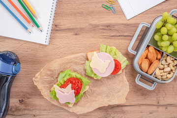 Creative school lunch with open sandwiches decorated with butterfly-shaped cheese and ham, served...
