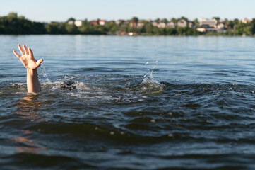 Man drowning in a lake is raising his hand asking for help