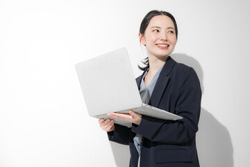パソコン持って立つ振り返るの若いかわいい女性のビジネスイメージ上半身