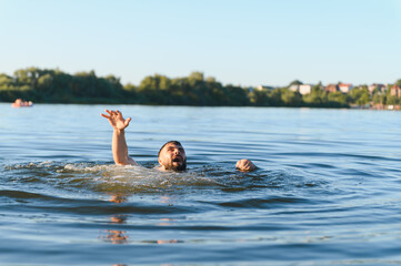 Man drowning in lake is raising hand asking for help