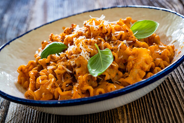 Creamy tomato and stracciatella reginelle noodles on wooden table
