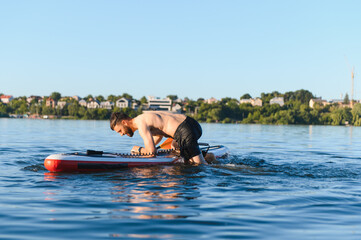 Man drowning while trying to get on paddle board in a lake