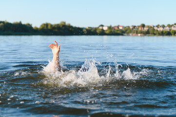 Man drowning in river is raising hand for help