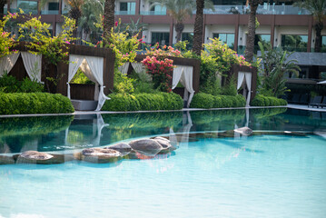 Loungers with white curtains and pool view 