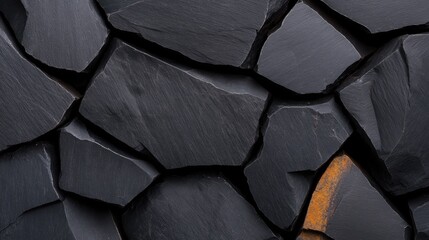 Cracked black rock displaying deep stone fractures and rugged geological texture in a natural environment