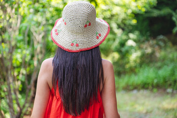 Woman with red dress and straw hat in the summer nature 