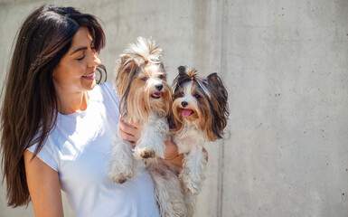 Beautiful smiling woman hugging two yorkies dogs 