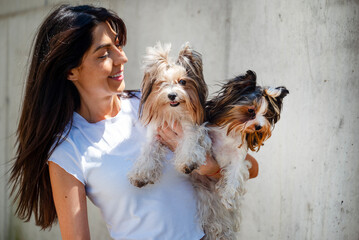 Beautiful smiling woman hugging two yorkies dogs 