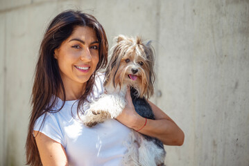 Beautiful woman hugging her yorkie dog outdoor 
