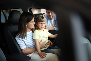 Family sitting inside new car. Luxury vehicle
