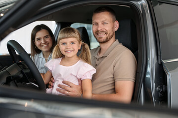 Happy family sitting inside new car. Luxury vehicle