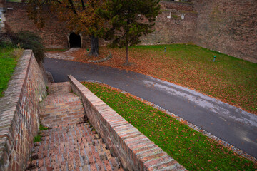 Autumn landscape with paths, trees, and fallen leaves in Belgrade Fortress. Concept of fall tourism in Serbia and other European destinations, exploring historic sites surrounded by seasonal beauty