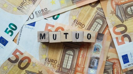 MUTUO (Mortgage) word made of wooden letter cubes on pile of Euro banknotes