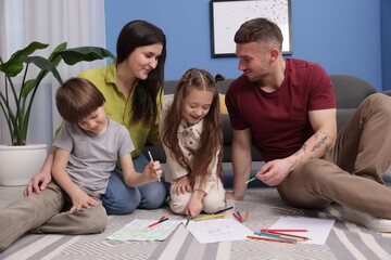 Parents teaching their kids to draw on floor at home