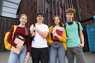 Group of happy teenagers near building outdoors