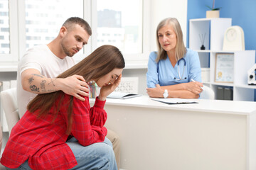Fototapeta premium In vitro fertilization (IVF). Upset couple having consultation with doctor in reproductive clinic