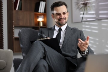 Professional psychologist having online consultation with his client via laptop indoors