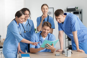 Medical students in uniforms studying together at university