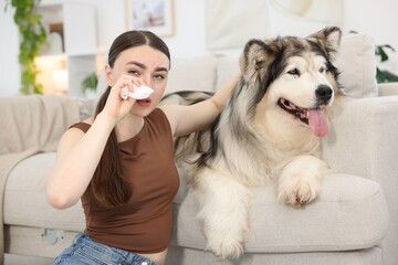 Woman suffering from allergy with her dog at home