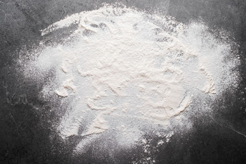 Flat lay cooking background of flour laying on slate board with copy-space.