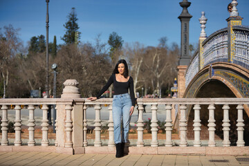 Young, beautiful, brunette woman in black long sleeve t-shirt and jeans, relaxed and calm, posing...